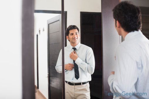 Businessman adjusting his necktie in front of a mirror